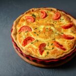 Close-up photo of classic quiche lorraine pie with tomatoes